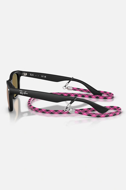 Occhiali da sole Ray-Ban RJ9052S 7028/7J Junior, montatura nero opaco su trasparente con lenti rosa specchiate.